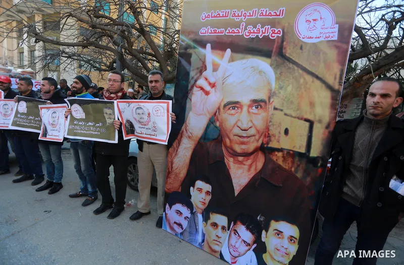 Palestinians hold placards during a protest to show solidarity with Palestinian prisoners held in Israeli Jails, in front of Red cross office in Gaza city, on January 30, 2017. Photo by Mohammed Asad