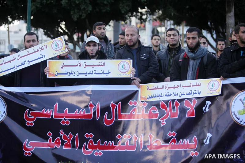 Palestinian supporters of the Islamic Jihad Movement hold placards during a protest against the security coordination and the political arrests in the West Bank, in Gaza city on January 31, 2017. Photo by Ashraf Amra