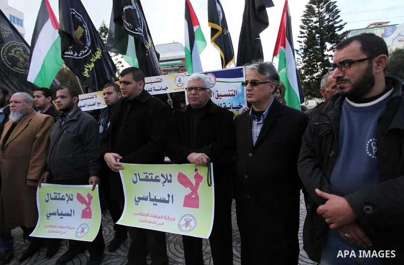 Palestinian supporters of the Islamic Jihad Movement hold placards during a protest against the security coordination and the political arrests in the West Bank, in Gaza city on January 31, 2017. Photo by Ashraf Amra