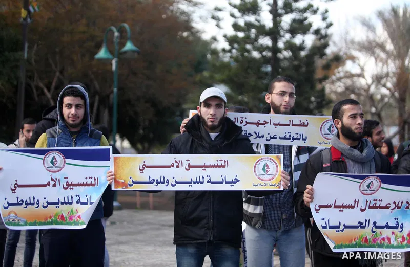 Palestinian supporters of the Islamic Jihad Movement hold placards during a protest against the security coordination and the political arrests in the West Bank, in Gaza city on January 31, 2017. Photo by Ashraf Amra