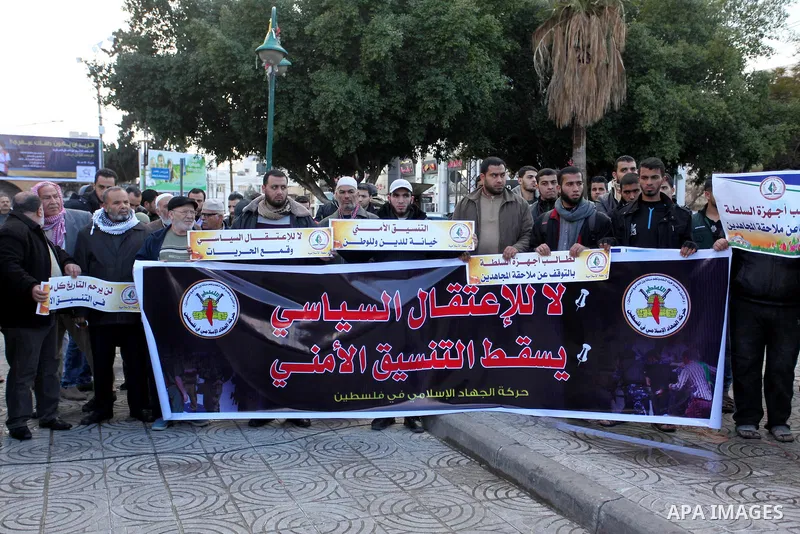 Palestinian supporters of the Islamic Jihad Movement hold placards during a protest against the security coordination and the political arrests in the West Bank, in Gaza city on January 31, 2017. Photo by Ashraf Amra