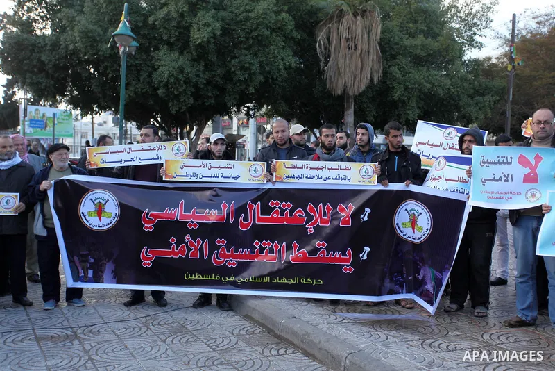 Palestinian supporters of the Islamic Jihad Movement hold placards during a protest against the security coordination and the political arrests in the West Bank, in Gaza city on January 31, 2017. Photo by Ashraf Amra