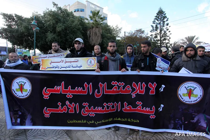 Palestinian supporters of the Islamic Jihad Movement hold placards during a protest against the security coordination and the political arrests in the West Bank, in Gaza city on January 31, 2017. Photo by Ashraf Amra
