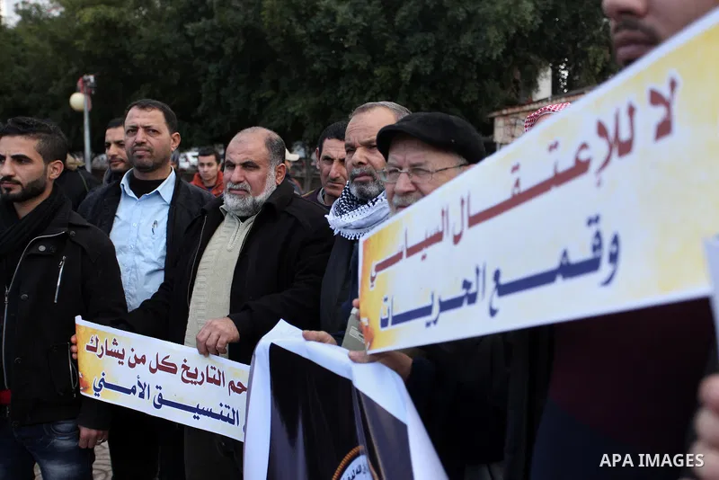 Palestinian supporters of the Islamic Jihad Movement hold placards during a protest against the security coordination and the political arrests in the West Bank, in Gaza city on January 31, 2017. Photo by Ashraf Amra