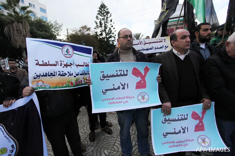 Palestinian supporters of the Islamic Jihad Movement hold placards during a protest against the security coordination and the political arrests in the West Bank, in Gaza city on January 31, 2017. Photo by Ashraf Amra