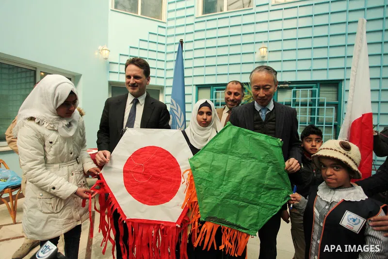 Japanese Ambassador to Palestine, Takeshi Okubo, and Commissioner-General of the UN Relief and Works Agency (UNRWA) Pierre Krahenbuhl, help Palestinian students to prepare kites at the headquarters United Nations Relief...