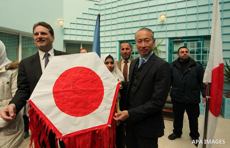 Japanese Ambassador to Palestine, Takeshi Okubo, and Commissioner-General of the UN Relief and Works Agency (UNRWA) Pierre Krahenbuhl, help Palestinian students to prepare kites at the headquarters United Nations Relief...