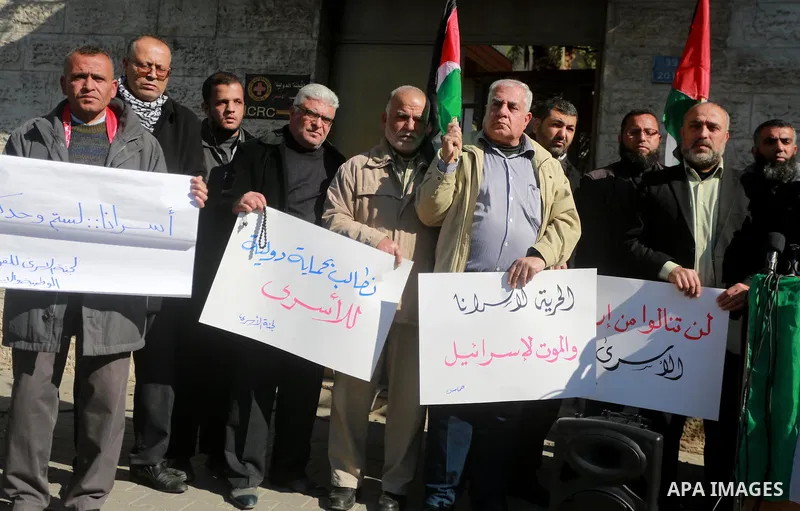 Palestinians hold placards during a protest to show solidarity with Palestinian prisoners held in Israeli Jails, in front of Red cross office in Gaza city, on February 2, 2017. Photo by Mohammed Asad