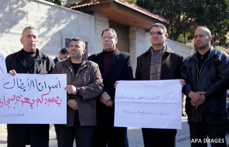 Palestinians hold placards during a protest to show solidarity with Palestinian prisoners held in Israeli Jails, in front of Red cross office in Gaza city, on February 2, 2017. Photo by Mohammed Asad