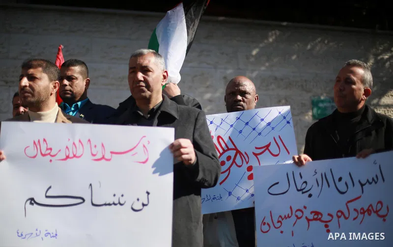 Palestinians hold placards during a protest to show solidarity with Palestinian prisoners held in Israeli Jails, in front of Red cross office in Gaza city, on February 2, 2017. Photo by Mohammed Asad