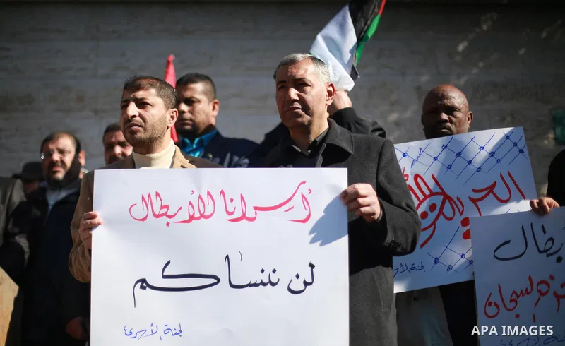 Palestinians hold placards during a protest to show solidarity with Palestinian prisoners held in Israeli Jails, in front of Red cross office in Gaza city, on February 2, 2017. Photo by Mohammed Asad
