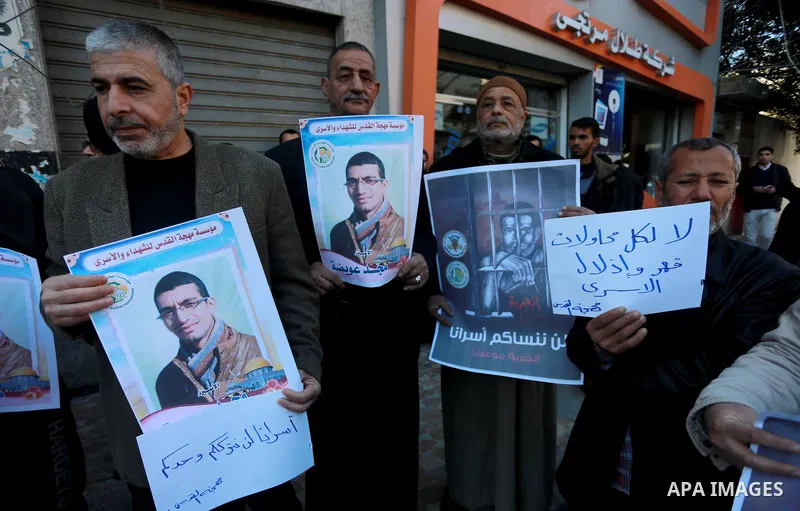 Palestinians hold placards during a protest to show solidarity with Palestinian prisoners held in Israeli Jails, in Gaza city, on February 2, 2017. Photo by Mohammed Asad