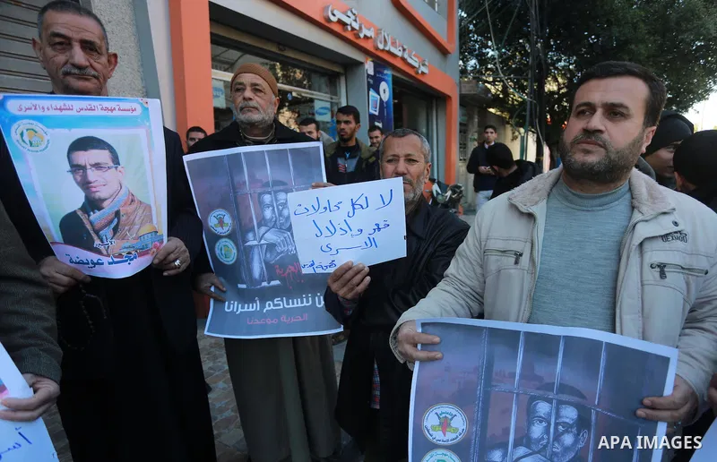 Palestinians hold placards during a protest to show solidarity with Palestinian prisoners held in Israeli Jails, in Gaza city, on February 2, 2017. Photo by Mohammed Asad