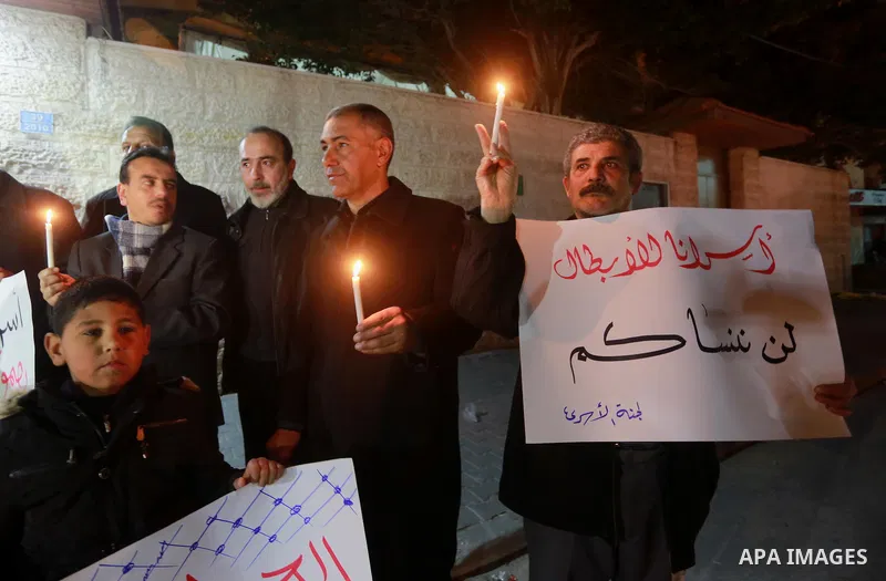 Palestinians hold placards and light candles during a protest to show solidarity with Palestinian prisoners held in Israeli Jails, in front of Red cross office in Gaza city, on February 2, 2017. Photo by Mohammed Asad