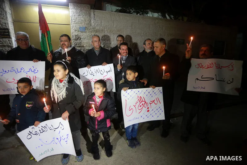 Palestinians hold placards and light candles during a protest to show solidarity with Palestinian prisoners held in Israeli Jails, in front of Red cross office in Gaza city, on February 2, 2017. Photo by Mohammed Asad