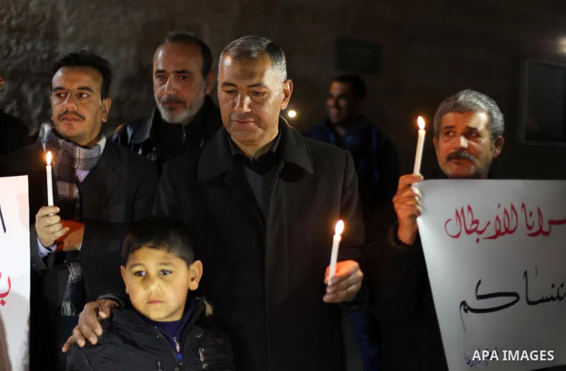 Palestinians hold placards and light candles during a protest to show solidarity with Palestinian prisoners held in Israeli Jails, in front of Red cross office in Gaza city, on February 2, 2017. Photo by Mohammed Asad