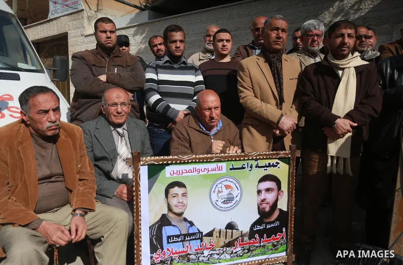 Palestinians hold placards during a protest to show solidarity with Palestinian prisoners held in Israeli Jails, in Gaza city, on February 4, 2017. Photo by Mohammed Asad