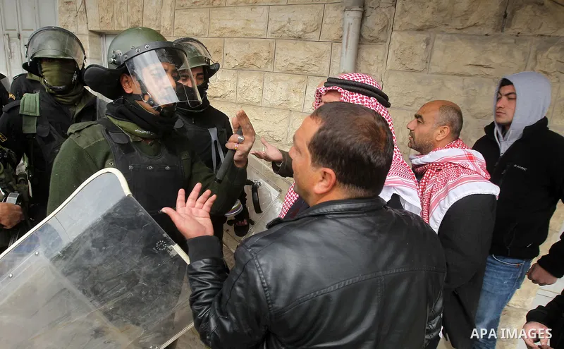 Protesters argue with a Palestinian policemen during a demonstration organised by Hizb ut-Tahrir against what they say is a decision by Palestinian Authority granting an Islamic land to a Russian church, in the West Bank...