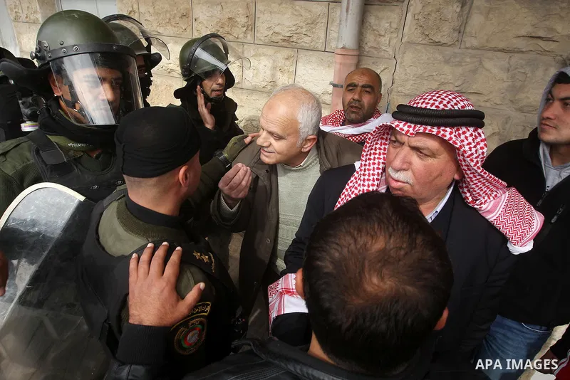 Protesters argue with a Palestinian policemen during a demonstration organised by Hizb ut-Tahrir against what they say is a decision by Palestinian Authority granting an Islamic land to a Russian church, in the West Bank...