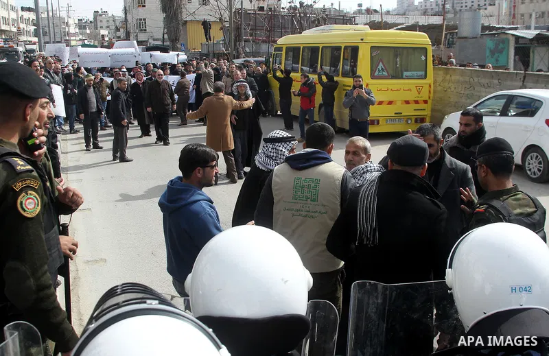 Protesters argue with a Palestinian policemen during a demonstration organised by Hizb ut-Tahrir against what they say is a decision by Palestinian Authority granting an Islamic land to a Russian church, in the West Bank...