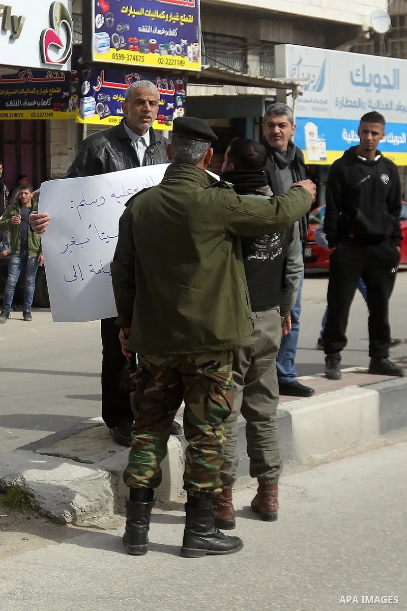 Protesters argue with a Palestinian policemen during a demonstration organised by Hizb ut-Tahrir against what they say is a decision by Palestinian Authority granting an Islamic land to a Russian church, in the West Bank...