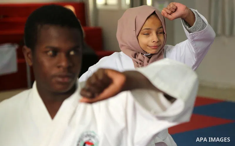 A Palestinian blind girl, Menna Allah al Bitar, takes part in a Karate class at the club Mashtal in Gaza city on February 5, 2017. The training is held twice a week by the club to lift the morale of the children, trainer...