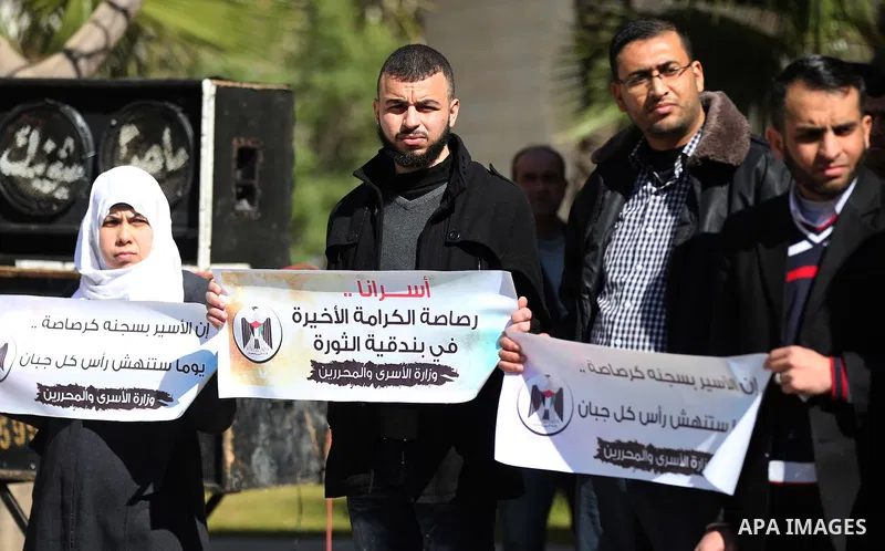 Palestinians hold placards during a protest to show solidarity with Palestinian prisoners held in Israeli Jails, in Gaza city, on February 5, 2017. Photo by Ashraf Amra
