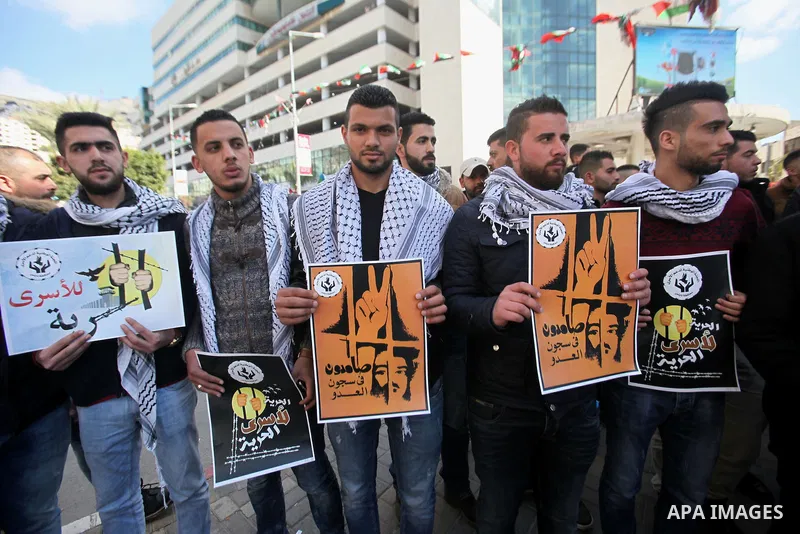 Palestinians hold placards during a protest to show solidarity with Palestinian prisoners held in Israeli Jails, in the West Bank city of Nablus, on Feb. 06, 2017. Photo by Stranger