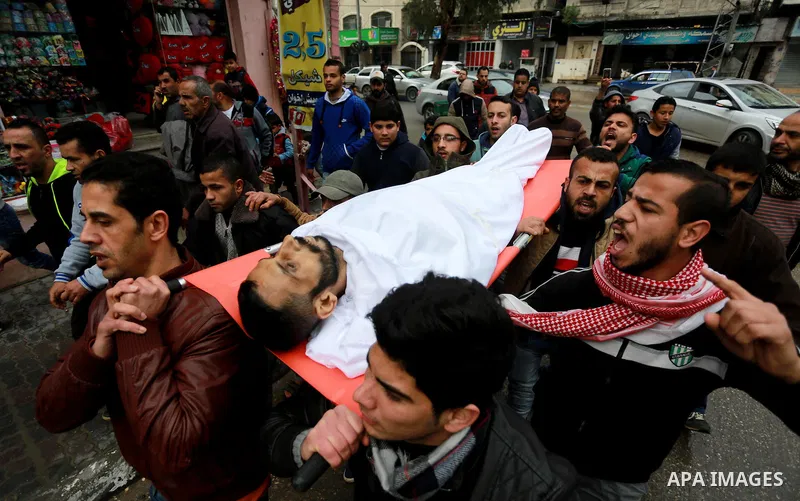 Mourners carry the body of Palestinian Mohammed al-Aqraa, who was killed in a tunnel explosion near the Egyptian border, during his funeral in Gaza City February 9, 2017. Photo by Mohammed Asad