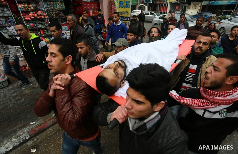 Mourners carry the body of Palestinian Mohammed al-Aqraa, who was killed in a tunnel explosion near the Egyptian border, during his funeral in Gaza City February 9, 2017. Photo by Mohammed Asad