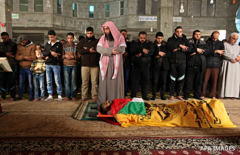 Palestinians pray on the body of Mohammed al-Aqraa, who was killed in a tunnel explosion near the Egyptian border before his funeral, in Gaza City February 9, 2017. Photo by Ashraf Amra