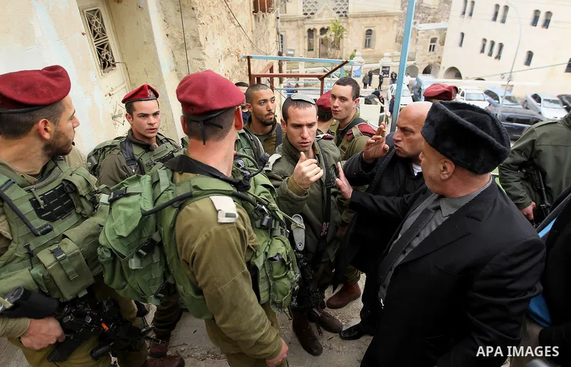 Palestinian protesters argue with Israeli army officers during a protest calling for reopening a closed street in the West Bank city of Hebron February 9, 2017. Photo by Wisam Hashlamoun