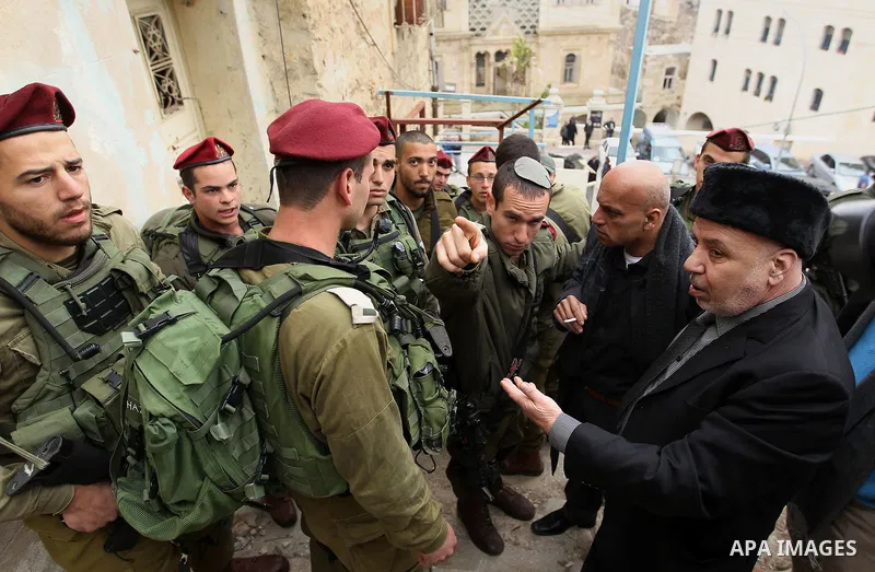 Palestinian protesters argue with Israeli army officers during a protest calling for reopening a closed street in the West Bank city of Hebron February 9, 2017. Photo by Wisam Hashlamoun