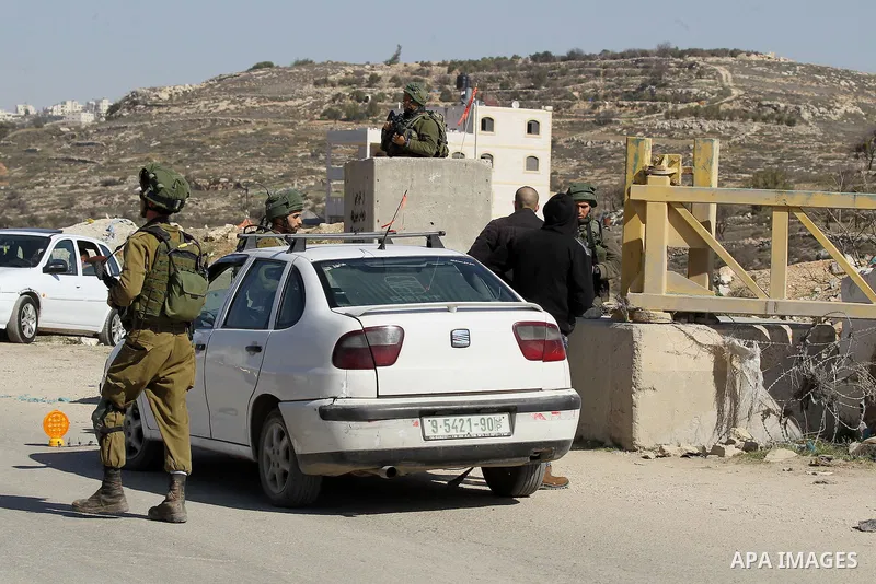 Israeli army soldiers check the cars following a demonstration against the construction of Jewish settlements in the occupied West Bank city of Hebron, on February 10, 2017. Photo by Wisam Hashlamoun