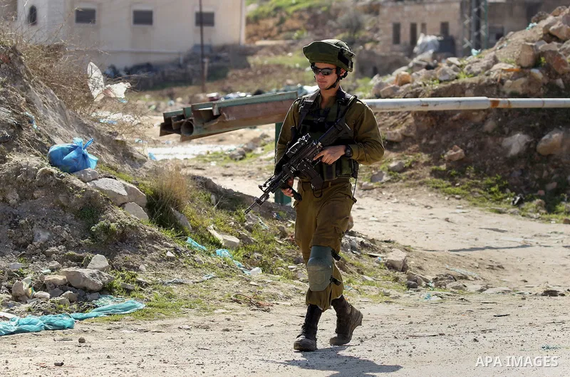 Israeli army soldiers check the cars following a demonstration against the construction of Jewish settlements in the occupied West Bank city of Hebron, on February 10, 2017. Photo by Wisam Hashlamoun