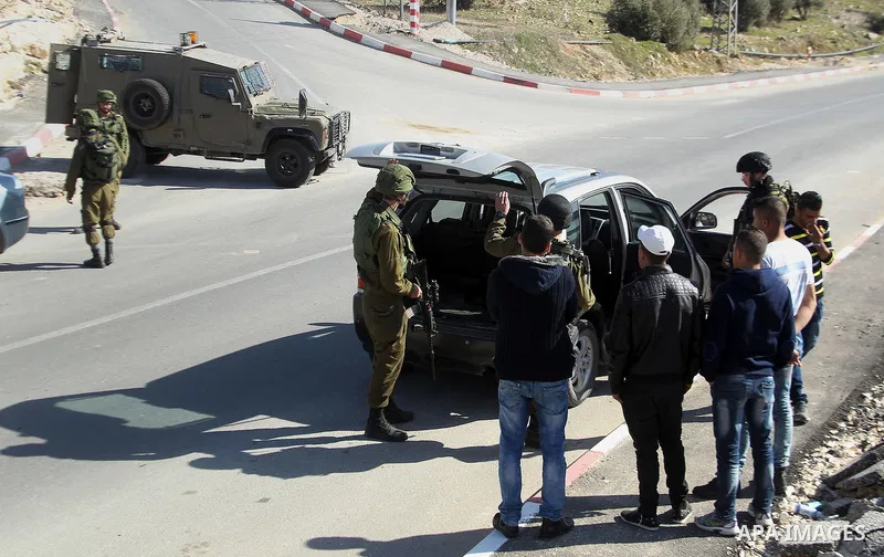 Israeli army soldiers check the cars following a demonstration against the construction of Jewish settlements in the occupied West Bank city of Hebron, on February 10, 2017. Photo by Wisam Hashlamoun