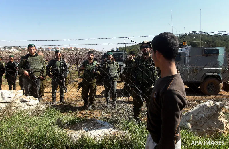 Israeli army soldiers check the cars following a demonstration against the construction of Jewish settlements in the occupied West Bank city of Hebron, on February 10, 2017. Photo by Wisam Hashlamoun
