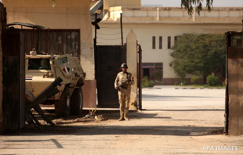 An Egyptian soldier stands guard as Palestinians wait for travel permits to cross into Egypt through the Rafah border crossing after it was opened by Egyptian authorities for humanitarian cases, in Rafah in the southern...