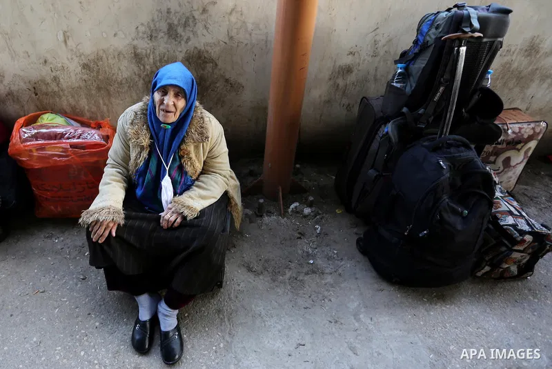 An elderly Palestinian woman waits for travel permits to cross into Egypt through the Rafah border crossing after it was opened by Egyptian authorities for humanitarian cases, in Rafah in the southern Gaza Strip on Febru...