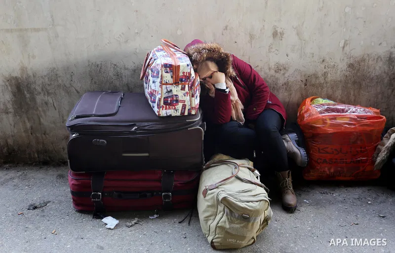 A Palestinian woman waits for travel permits to cross into Egypt through the Rafah border crossing after it was opened by Egyptian authorities for humanitarian cases, in Rafah in the southern Gaza Strip on February 11, 2...