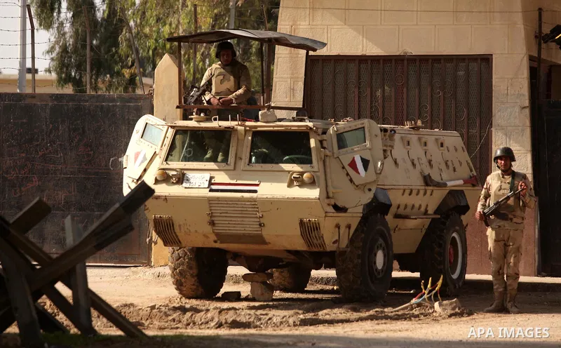 Egyptian soldiers stand guard as Palestinians wait for travel permits to cross into Egypt through the Rafah border crossing after it was opened by Egyptian authorities for humanitarian cases, in Rafah in the southern Gaz...