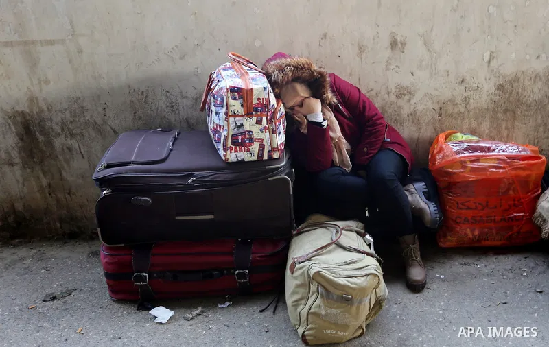 A Palestinian woman waits for travel permits to cross into Egypt through the Rafah border crossing after it was opened by Egyptian authorities for humanitarian cases, in Rafah in the southern Gaza Strip on February 11, 2...