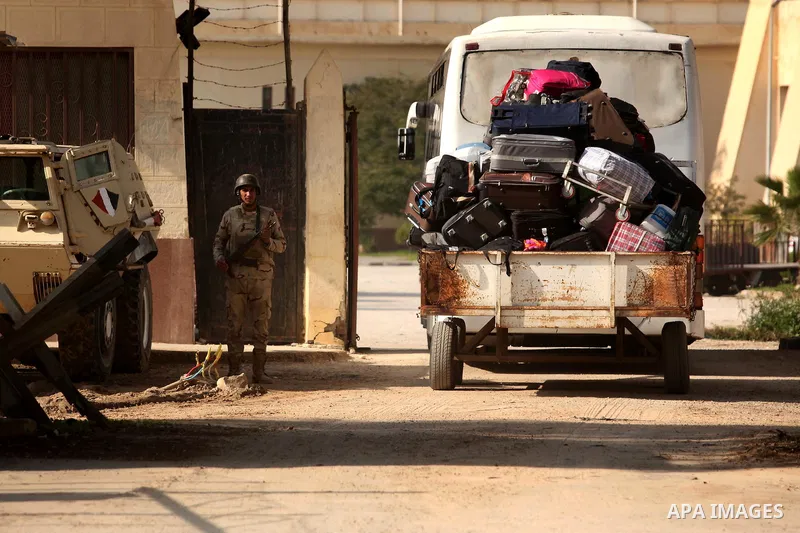 An Egyptian soldier stands guard as Palestinians wait for travel permits to cross into Egypt through the Rafah border crossing after it was opened by Egyptian authorities for humanitarian cases, in Rafah in the southern...