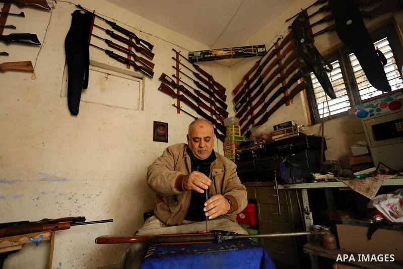 Khalil Taima, a 53-year-old Palestinian man, fixes the barrel of an air rifle used for target-shooting and hunting at his shop in the Nuseirat refugee camp in the central Gaza Strip on February 13, 2017. Photo by Ashraf...