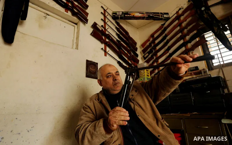 Khalil Taima, a 53-year-old Palestinian man, fixes the barrel of an air rifle used for target-shooting and hunting at his shop in the Nuseirat refugee camp in the central Gaza Strip on February 13, 2017. Photo by Ashraf...