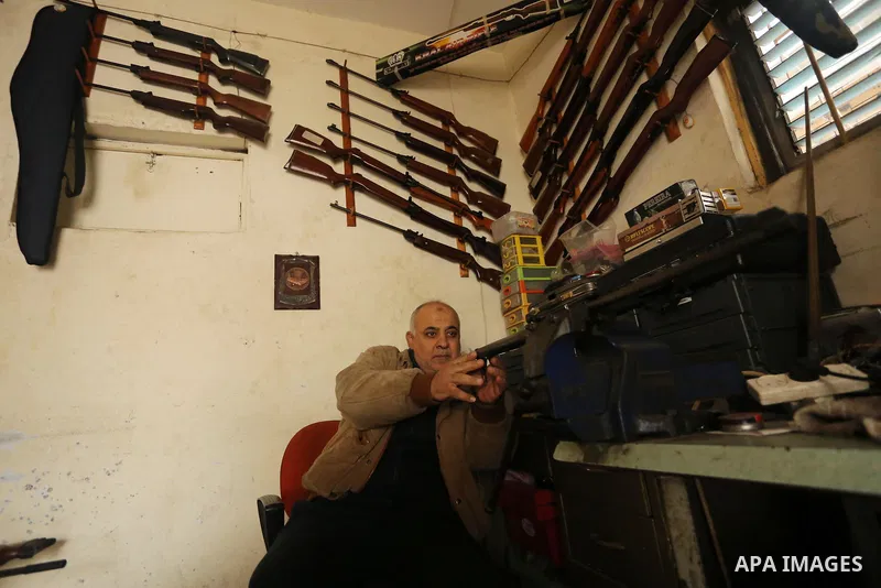 Khalil Taima, a 53-year-old Palestinian man, fixes the barrel of an air rifle used for target-shooting and hunting at his shop in the Nuseirat refugee camp in the central Gaza Strip on February 13, 2017. Photo by Ashraf...