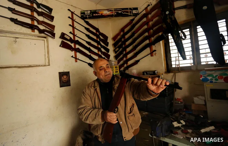 Khalil Taima, a 53-year-old Palestinian man, fixes the barrel of an air rifle used for target-shooting and hunting at his shop in the Nuseirat refugee camp in the central Gaza Strip on February 13, 2017. Photo by Ashraf...