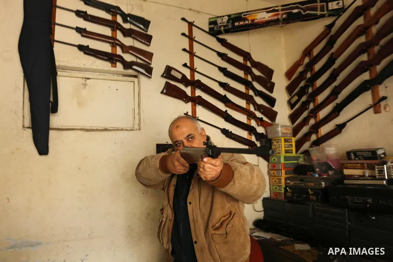 Khalil Taima, a 53-year-old Palestinian man, fixes the barrel of an air rifle used for target-shooting and hunting at his shop in the Nuseirat refugee camp in the central Gaza Strip on February 13, 2017. Photo by Ashraf...