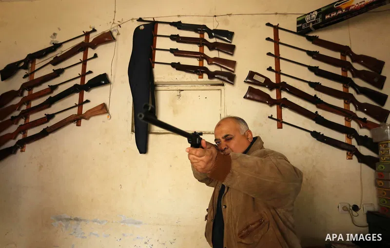 Khalil Taima, a 53-year-old Palestinian man, fixes the barrel of an air rifle used for target-shooting and hunting at his shop in the Nuseirat refugee camp in the central Gaza Strip on February 13, 2017. Photo by Ashraf...