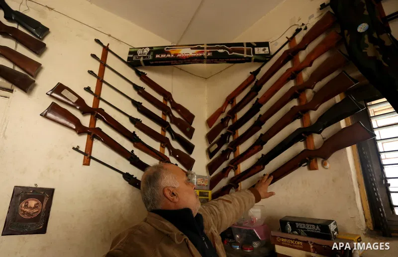 Khalil Taima, a 53-year-old Palestinian man, fixes the barrel of an air rifle used for target-shooting and hunting at his shop in the Nuseirat refugee camp in the central Gaza Strip on February 13, 2017. Photo by Ashraf...